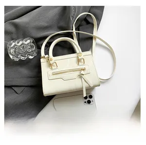 Detail of off-white crossbody bag with marble texture and phone for size comparison