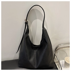 Detail view of the black retro leather hobo bag with a gold metal adjustable shoulder strap