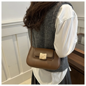 Close-up of vintage brown shoulder bag featuring a classic square gold metal buckle detail