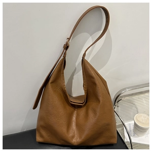Detail view of caramel brown faux leather Hobo bag with adjustable wide strap and texture