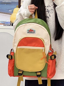 Close-up of multicolor nylon backpack with green, cream, orange panels and fashion patch