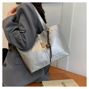 Detail of silver metallic tote bag with buckle closure and woven strap accessory