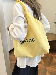Grand sac cabas jaune minimaliste avec lettres 'AREYOU' présenté dans un style décontracté