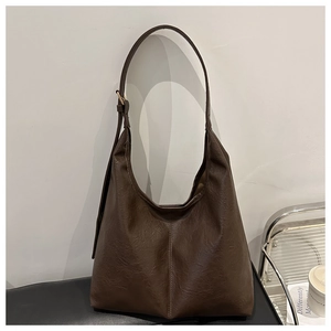 Detail view of dark brown tote bag with natural leather texture and vertical stitching