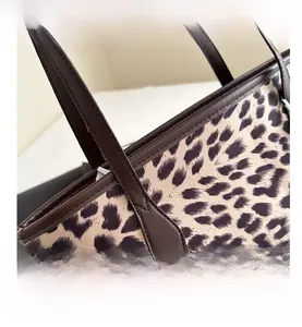 Detail showing leopard print texture and sturdy dark brown faux leather shoulder strap