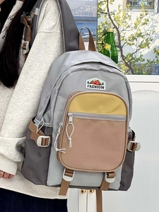 Detail of grey nylon backpack with yellow contrast pocket and side adjustable buckles