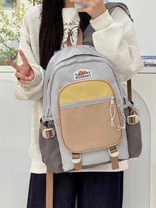 Detail of color-block nylon backpack with mountain logo patch and functional side buckles
