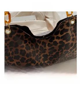 Close-up of leopard print handbag with amber acrylic chain handle and gold metal eyelets