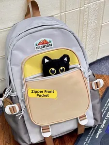 Detail of grey nylon backpack with fashion label, color blocking, and cute cat plush toy