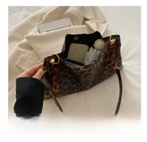 Detailed interior of large leopard print tote bag with acrylic chain and essentials