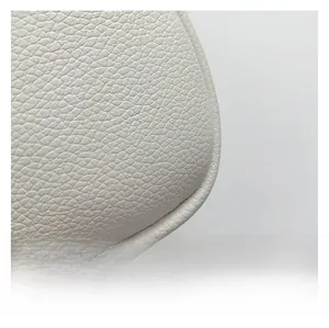 Close-up detail of premium white lychee grain leather texture on a round fashion handbag