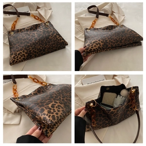 Detail of leopard print tote bag featuring resin chain strap and high capacity interior