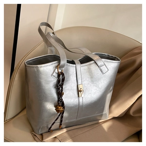 Close-up of metallic silver tote bag with golden twist lock and textured finish