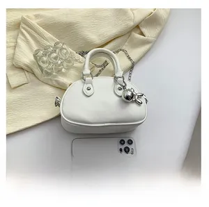 Mini white leather round bag detail with silver rabbit charm and chain strap