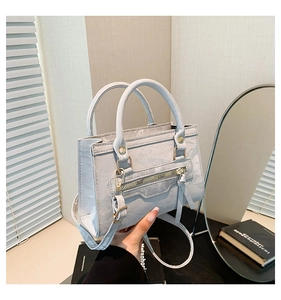 Close-up of the light blue textured PU leather handbag with elegant dual top handles