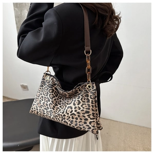 Detail of leopard print shoulder bag with amber acrylic chain and brown leather strap