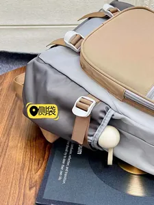Detail of color-blocked nylon backpack side pocket with white buckle and khaki strap