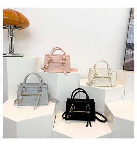 Selection of chic cross-body bags in pink, white, grey, and black on a modern display