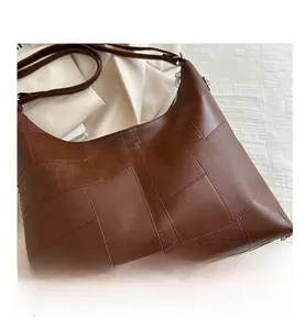 Close-up of brown patchwork leather tote bag with elegant texture and stitching details