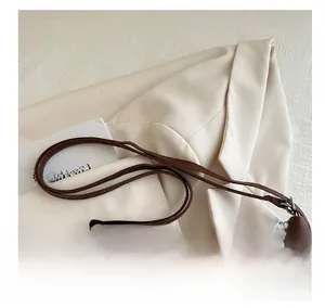 Detail of brown leather tote bag with double shoulder straps and silver metal hardware
