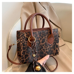 Close-up of leopard print PU leather bag with golden pendant on a camel blazer
