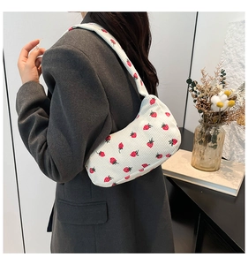 Détail du sac d'épaule en velours blanc avec motif fraise et fermeture éclair