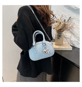 Close-up of a light blue mini handbag with silver chain strap and balloon dog charm