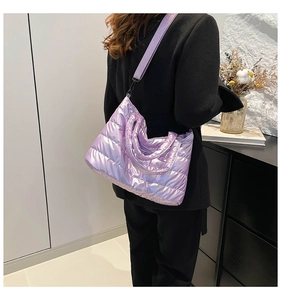 Detail der lila gesteppten Puffer-Tasche mit Glanzeffekt und passendem Stoff-Schultergurt