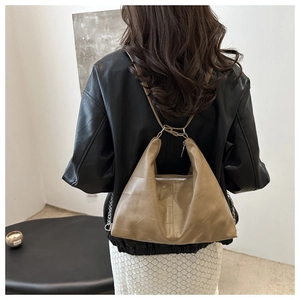 Detail of khaki leather patchwork shoulder bag with geometric stitching and metal zipper