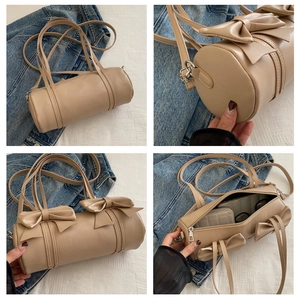 Detailansicht der beigen Zylindertasche mit süßen Schleifen und geräumigem Innenraum