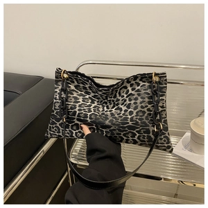 Detail of leopard print tote bag with black thick chain strap and metal buckles