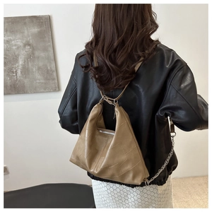 Detail view of khaki hobo shoulder bag with geometric stitching and silver chain