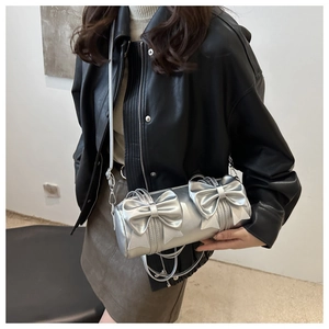 Detailansicht der silbernen Zylindertasche mit zwei großen Schleifen und Nähten