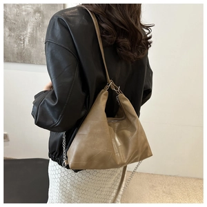 Detail of tan brown patchwork leather shoulder bag with chain and leather straps