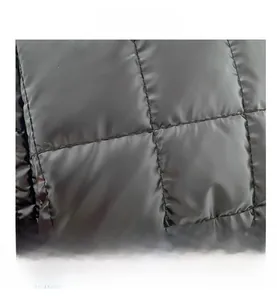 Close-up of black quilted nylon fabric with shiny texture and square stitching details