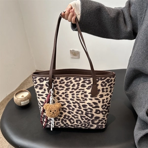 Vintage leopard print tote bag with brown leather straps and a plush bear charm