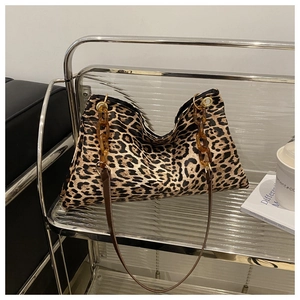 Detail of leopard print tote bag with stylish amber acrylic chain and leather strap