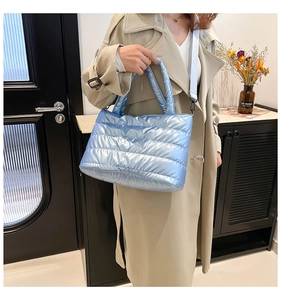 Sac à bandoulière matelassé bleu clair avec sangle amovible présenté sur un mannequin