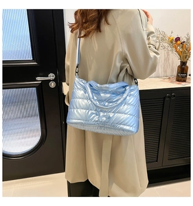 Détail du sac cabas matelassé bleu clair brillant avec bandoulière réglable chic