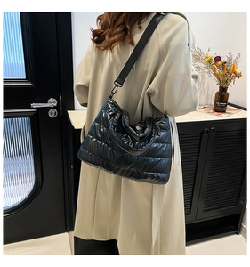 Détail du sac cabas matelassé noir brillant avec large bandoulière en nylon doux
