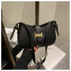 Close-up of black matte leather shoulder bag featuring a vintage gold H-shaped metal buckle