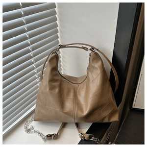 Detail view of khaki tote bag featuring lychee grain leather and silver chain strap