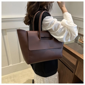 Dettaglio di una borsa tote vintage marrone scuro con ritagli strutturati e finitura in PU