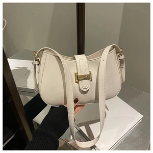 Detailed close-up of cream crescent saddle bag with gold buckle and smooth faux leather