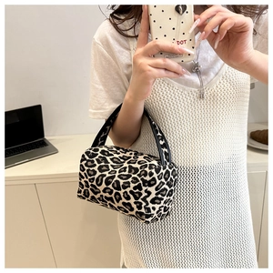 Mirror selfie showing a mini leopard print pillow bag with stylish black handles