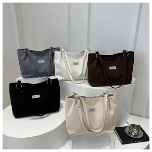 Dettagli borse tote in velluto a coste grigie, bianche, marroni e nere con etichetta moda