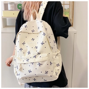 Detail eines Blumen-Schulrucksacks mit blauen Schleifenmustern und Fashion-Label