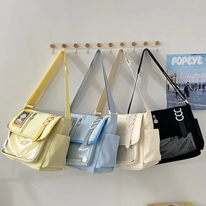 Detail of four colorful canvas messenger bags with transparent PVC windows and buckles