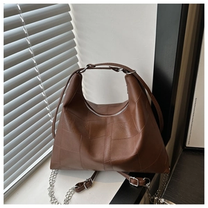 Detailed view of brown leather Hobo bag featuring mixed textures and silver hardware