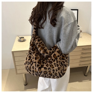 Sac fourre-tout tendance en peluche léopard porté par un mannequin dans un intérieur cosy